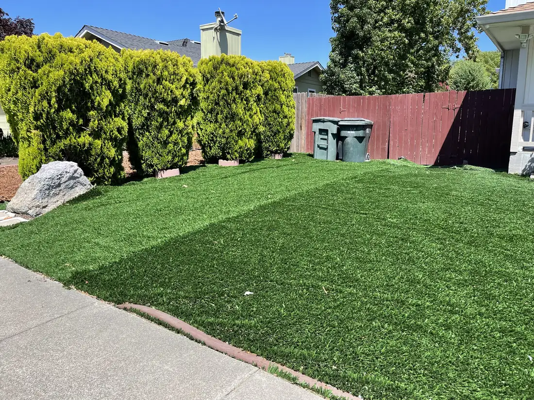 Artificial turf yard with leaf debris, dust and flattened fibers